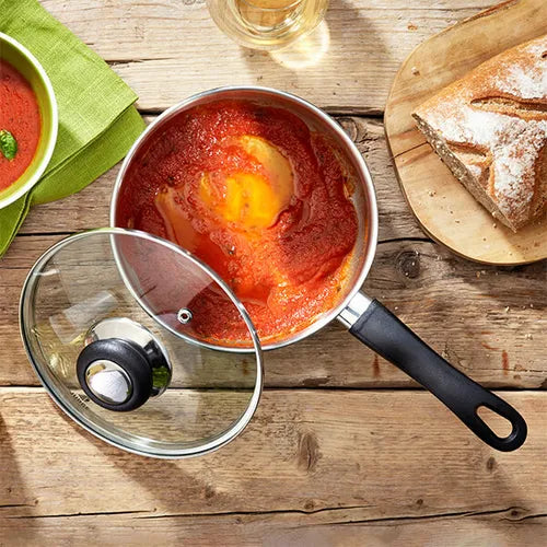 Judge Vista 16cm saucepan with tomato sauce and butter, glass lid beside, on wooden table with bread and soup bowl.