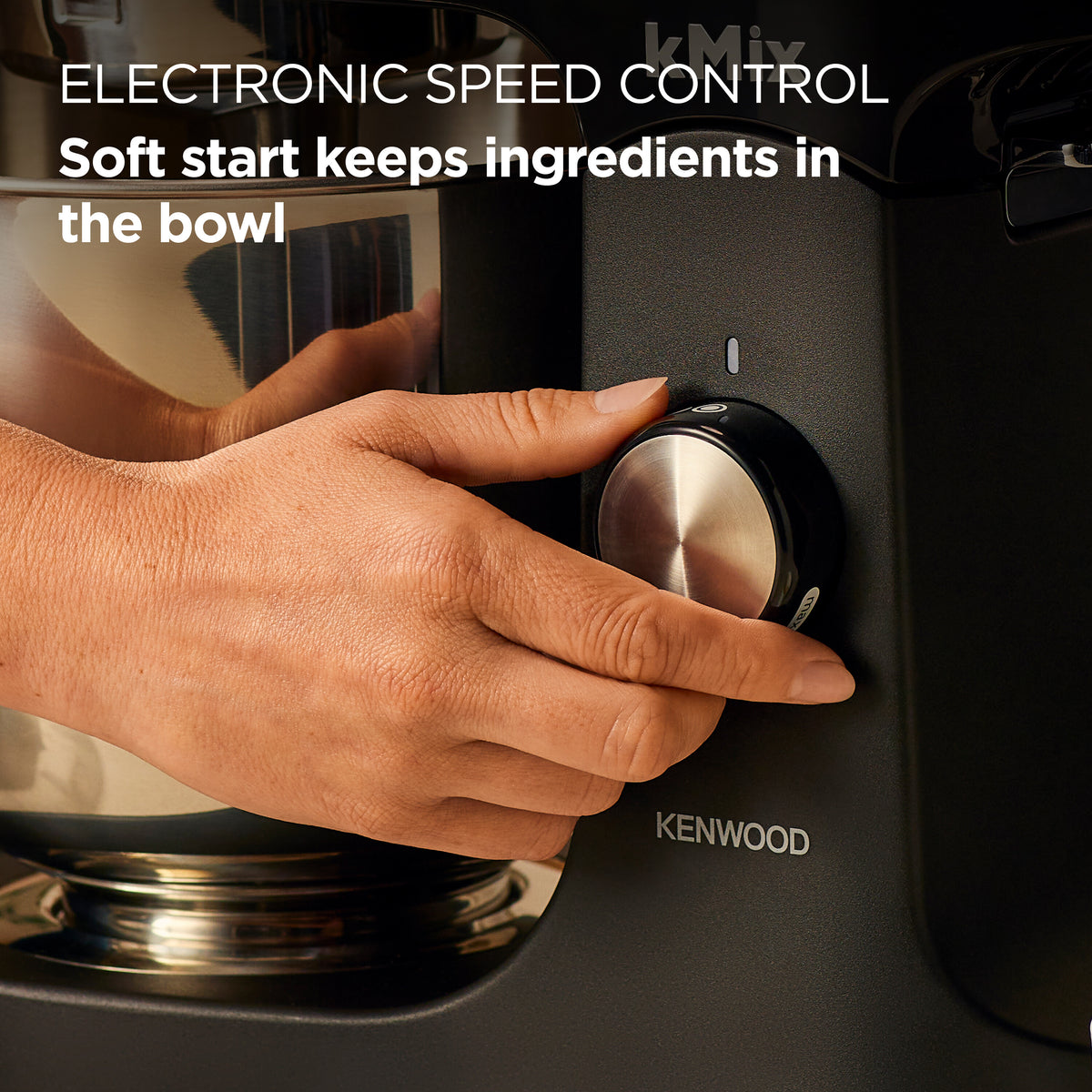 Close-up of a hand adjusting the speed control knob on the black Kenwood kMix Stand Mixer.