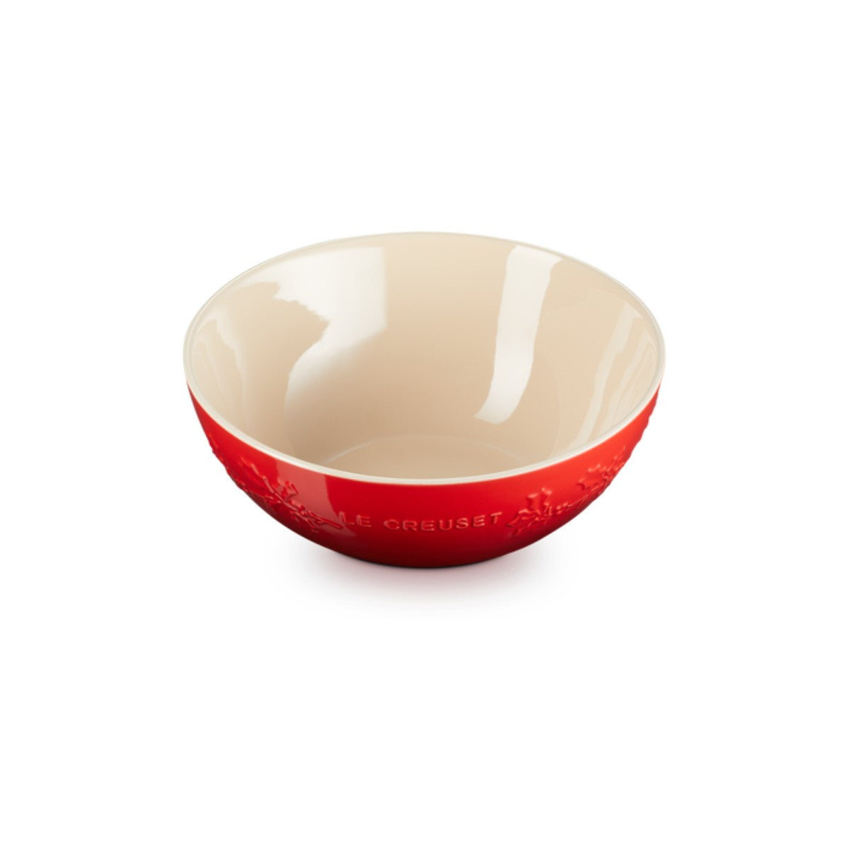 Le Creuset Christmas Holly mixing bowl in cerise red with embossed holly design and cream interior.