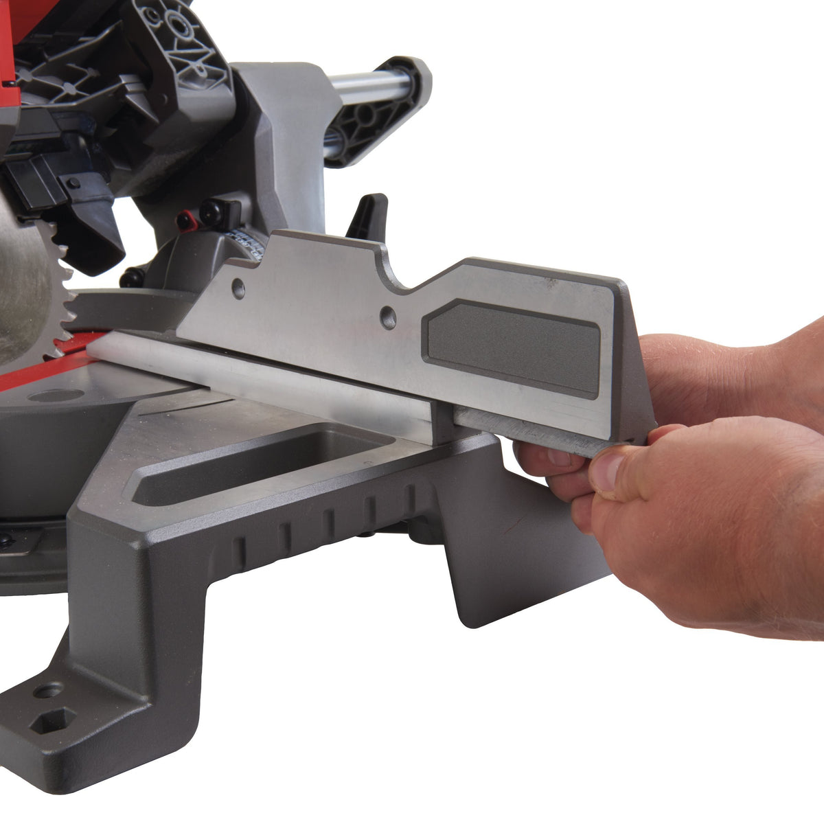 Close-up of a hand adjusting the fence on a Milwaukee M18 Fuel 190mm Mitre Saw base.