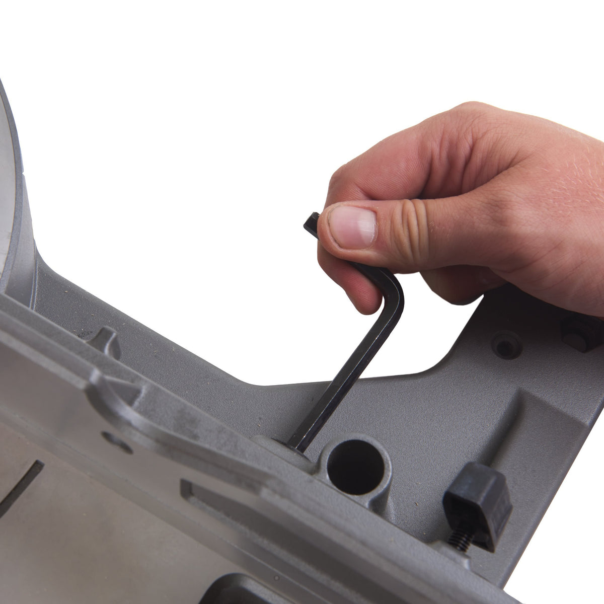 Close-up of a hand using an Allen wrench to adjust a component on the Milwaukee M18 Fuel 190mm Mitre Saw.