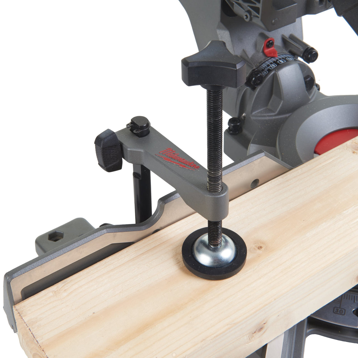 Close-up of Milwaukee M18 Fuel 190mm Mitre Saw clamp securing wood for cutting with angle adjustment dial visible