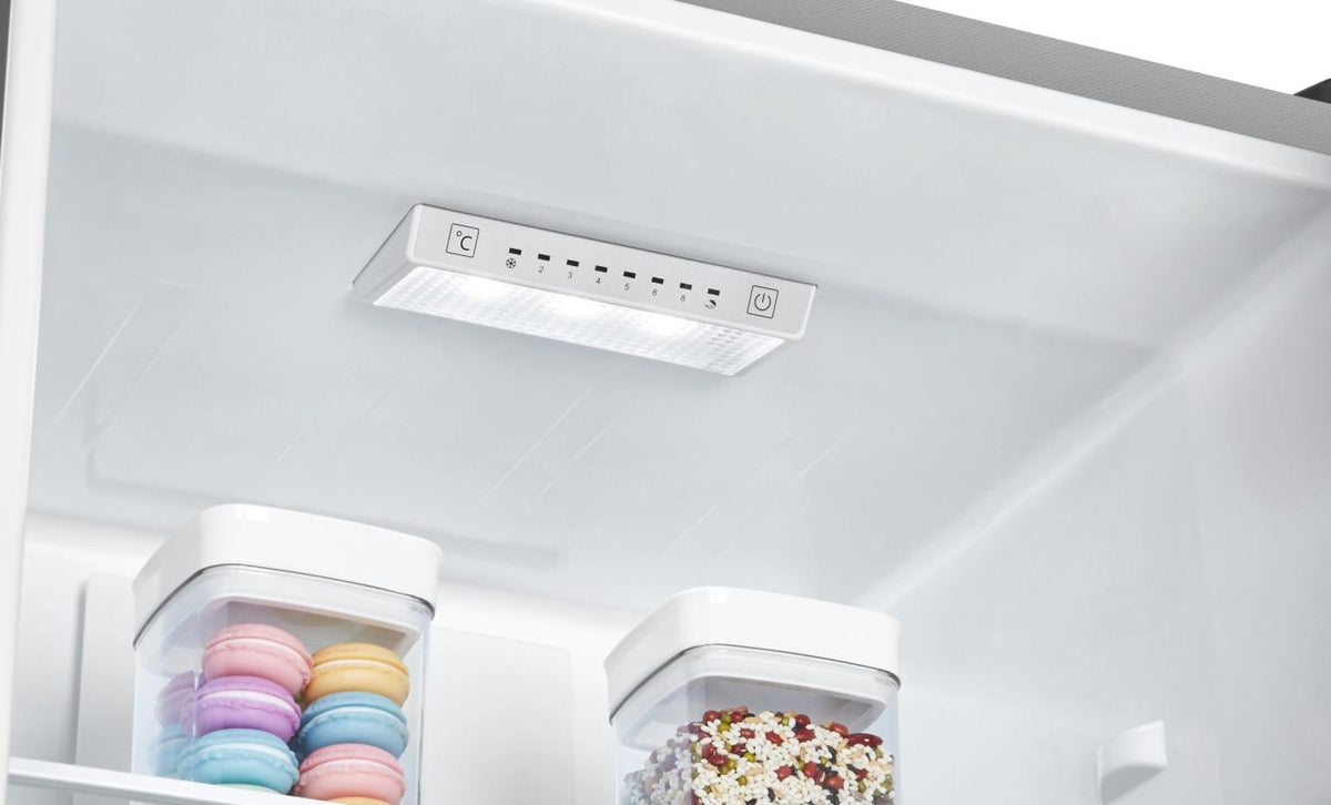 Interior light and temperature control panel inside Hisense stainless steel fridge freezer with containers of food.