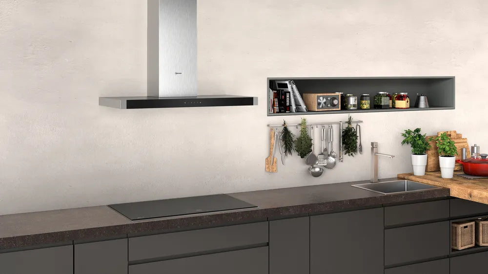 Neff N50 90cm stainless steel wall-mounted cooker hood above a modern kitchen countertop and stovetop.