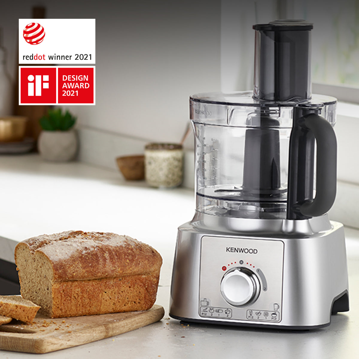 Kenwood MultiPro Express food processor with clear bowl and stainless steel base next to sliced bread on a wooden board