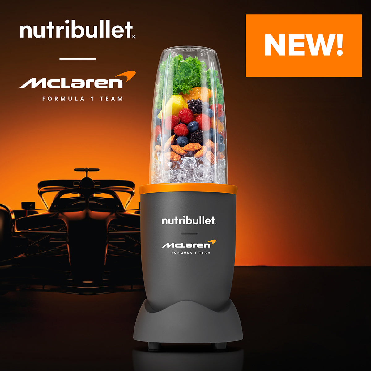 NutriBullet 900 McLaren grey blender with fruit, nuts, and ice in cup, Formula 1 car silhouette background.