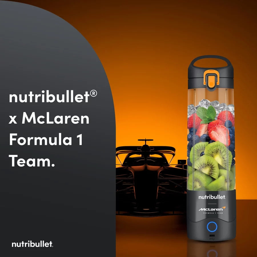 Nutribullet Portable McLaren blender in grey with fruit and ice inside, against an orange background with a race car