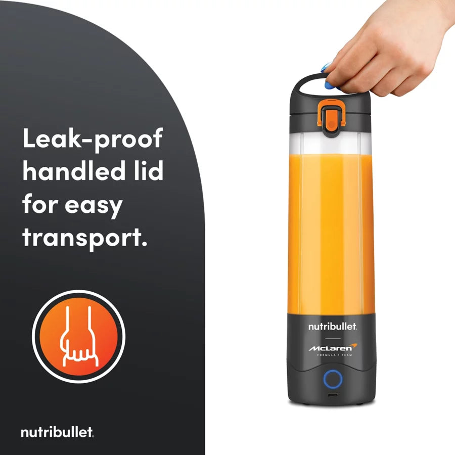 Nutribullet Portable McLaren grey blender bottle with orange juice and hand lifting the handled lid