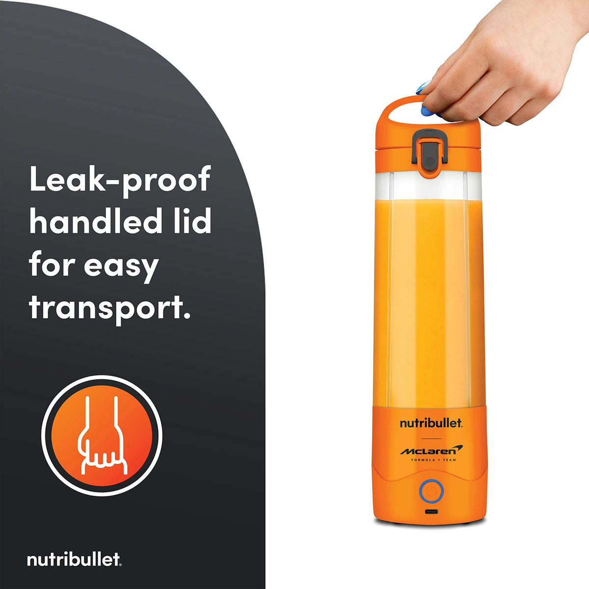 Hand holding the orange Nutribullet Portable McLaren blender by its leak-proof handled lid.