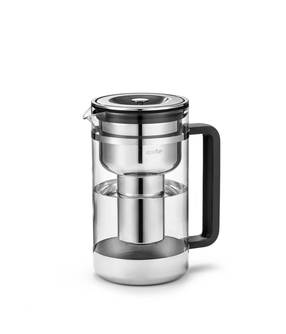 Aarke Purifier large glass water filter pitcher with stainless steel filter and black handle, side view.