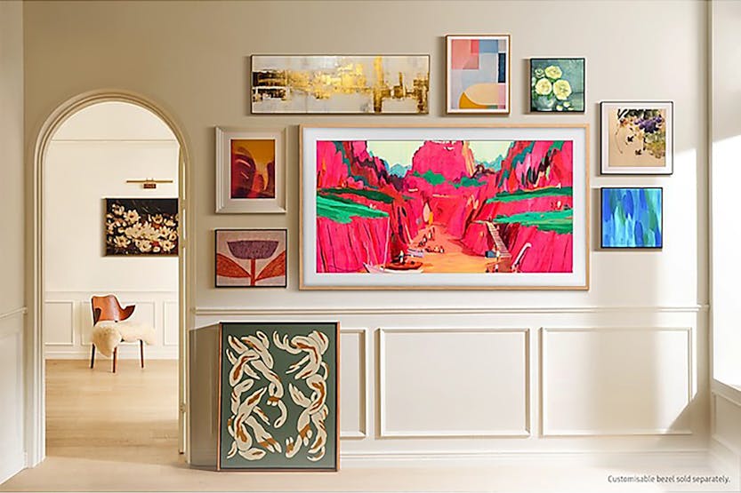 Samsung 65'' The Frame Pro Neo QLED 4K TV mounted on wall displaying vibrant red and green landscape artwork.