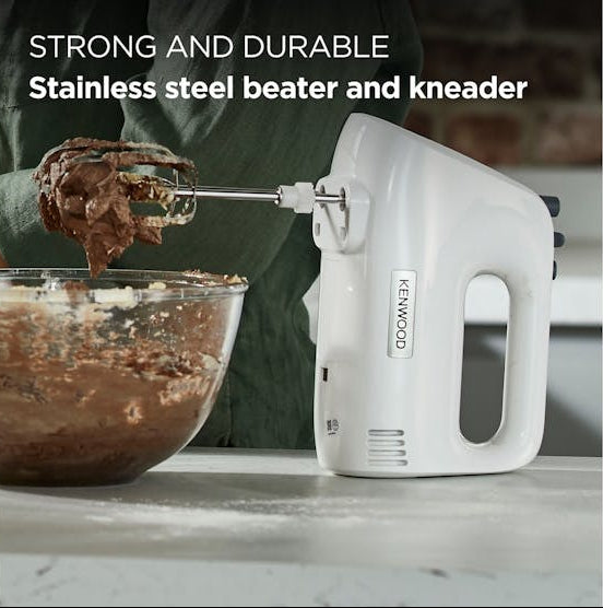 White Kenwood Lite Hand Mixer with stainless steel beaters mixing chocolate batter in a glass bowl