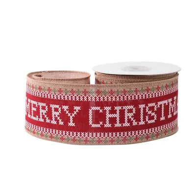 Merry Christmas cross stitch ribbon in red, white, and green on rustic fabric with wired edges, rolled on a spool.