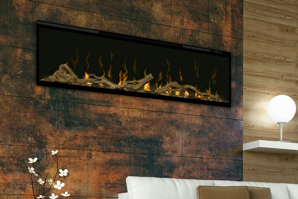Wall-mounted 50" LED Dimplex fireplace with driftwood and river rock fuel bed accessory lit with flames.