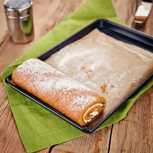 Stellar Bakeware non-stick Swiss roll tin 35x25x2 cm with baked Swiss roll on green cloth.