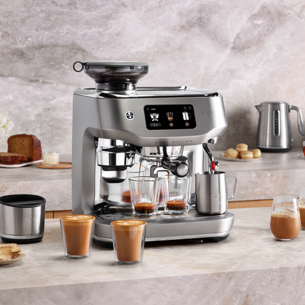 Sage Oracle Dual Boiler espresso machine brewing two shots with milk frother and two lattes on counter