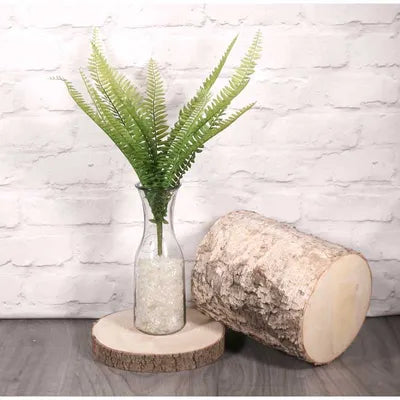 Artificial Boston Fern with realistic green fronds in a clear glass vase filled with white stones, 48 cm tall.