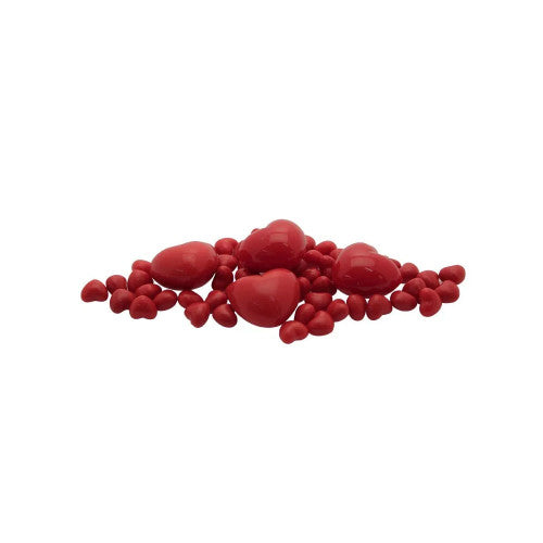 Assorted small and large coral pink plastic hearts scattered on white background