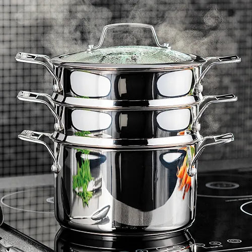 Stainless steel Stellar 16cm 3 tier steamer set with glass lid, steaming on a stovetop with visible steam.