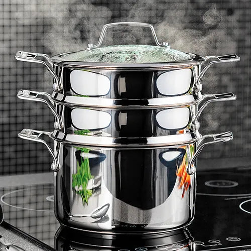 Stainless steel 24cm 3 tier steamer set with glass lid steaming vegetables on stovetop.