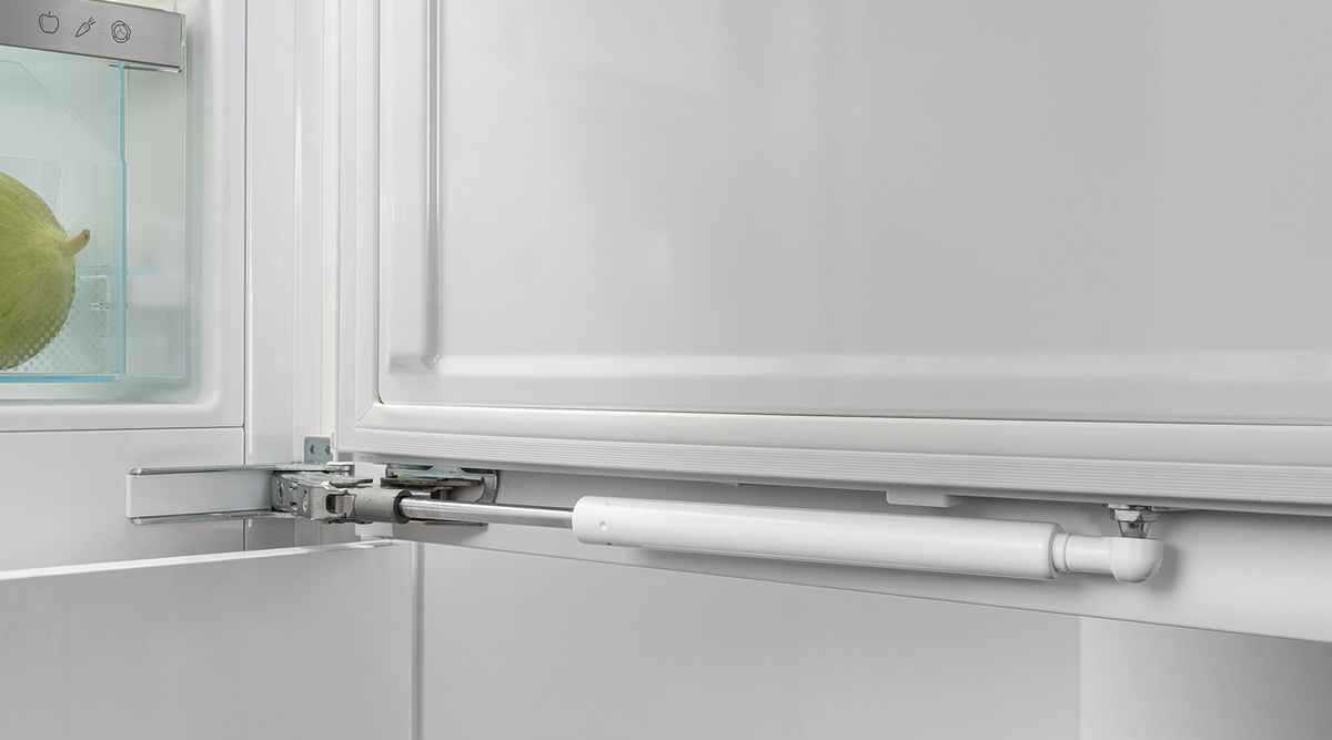 Close-up of Liebherr Plus fridge door hinge and soft-close mechanism inside the fully integrated fridge.