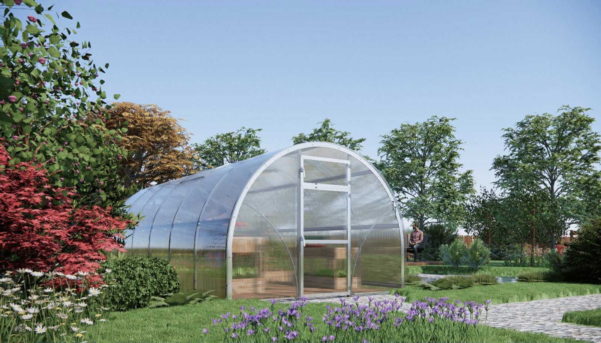 3m x 8m Sigma Lux greenhouse with 6mm polycarbonate panels in a garden setting with flowers and trees.