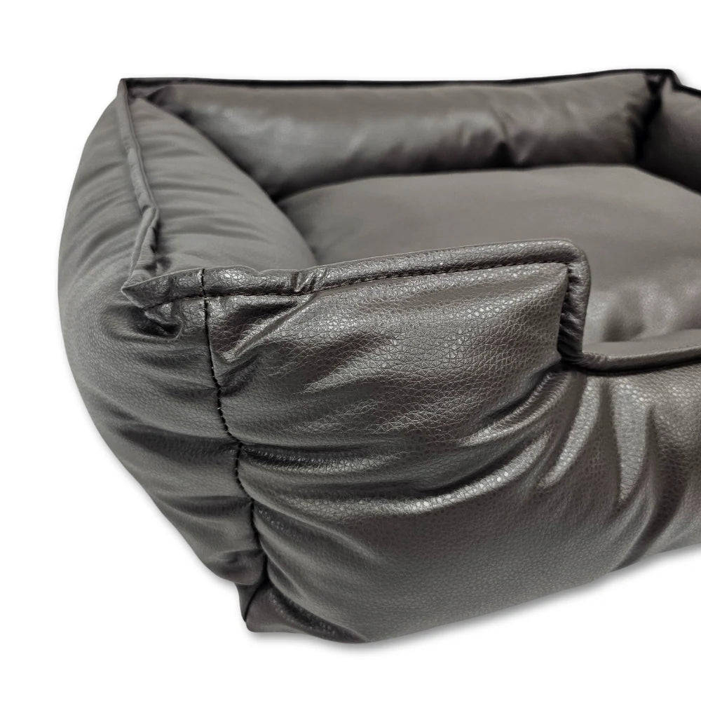 Close-up of a dark brown leather dog bed corner showing soft padded sides and stitching details.