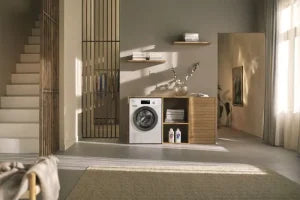 Miele 8kg 1400 Spin Washing Machine in a modern laundry room with wooden shelves and detergent bottles.