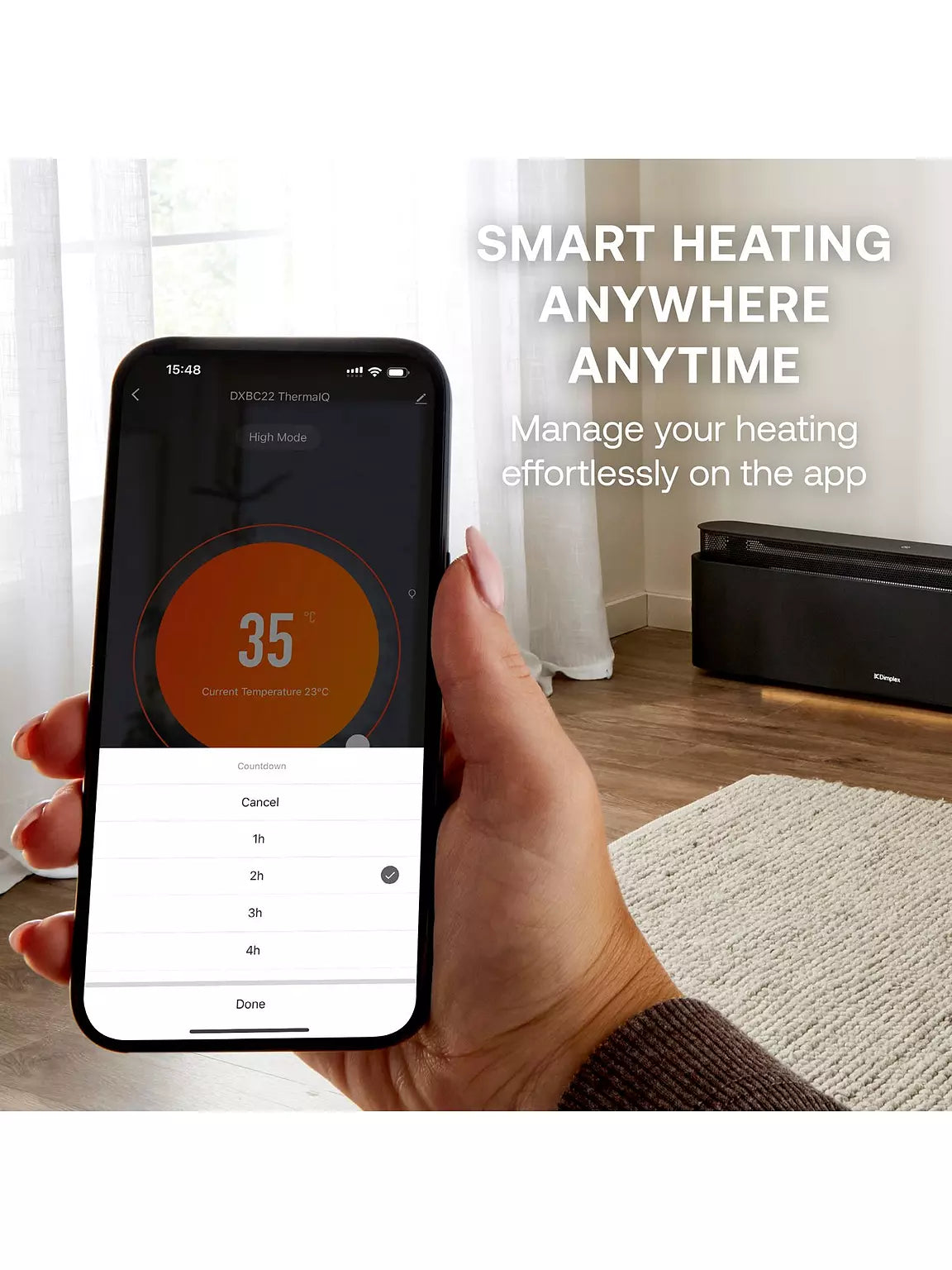 Hand holding phone showing app controlling Dimplex Thermaliq 2.2Kw baseboard heater in room corner.