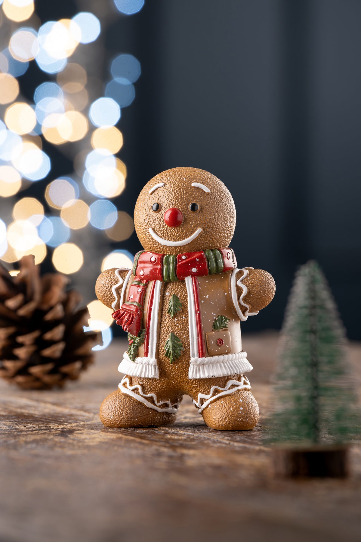 Aynsley Gingerbread Man figurine wearing a red and green scarf with white icing details, on a wooden surface.