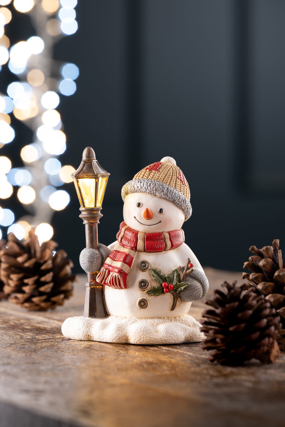 Aynsley Snowman Lamp Post LED figurine with red scarf, beige hat, holding a lit lamp post on snowy base.