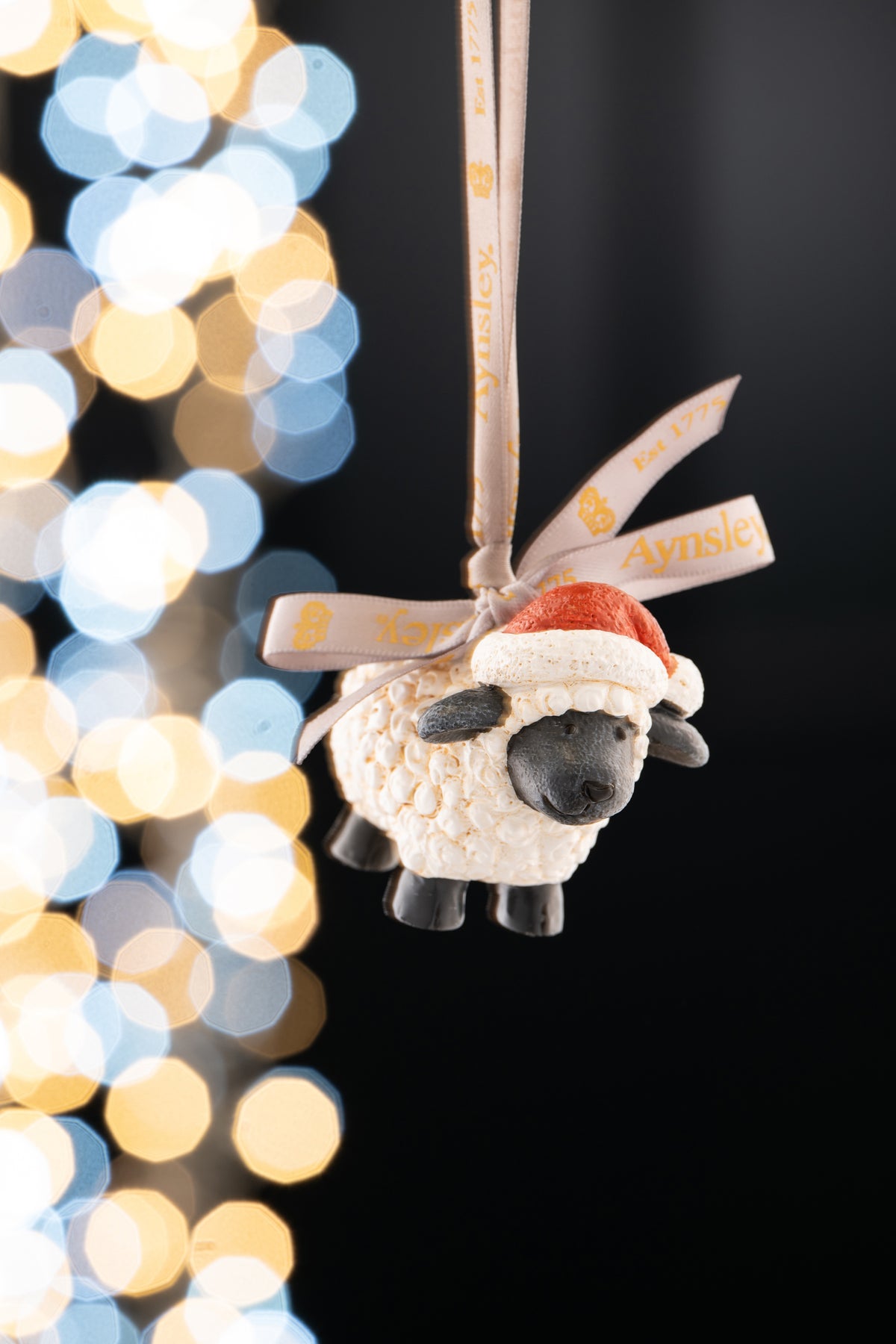 Aynsley Christmas Sheep Hanging Ornament with textured wool and red Santa hat, hanging by a branded ribbon