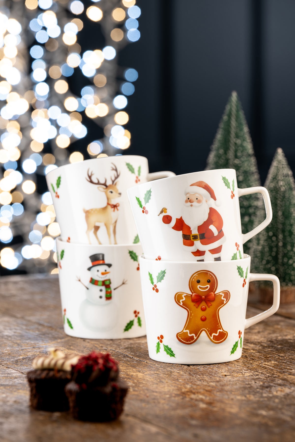Stacked Belleek Christmas Character mugs showing Santa, gingerbread, snowman, and reindeer designs with holly accents