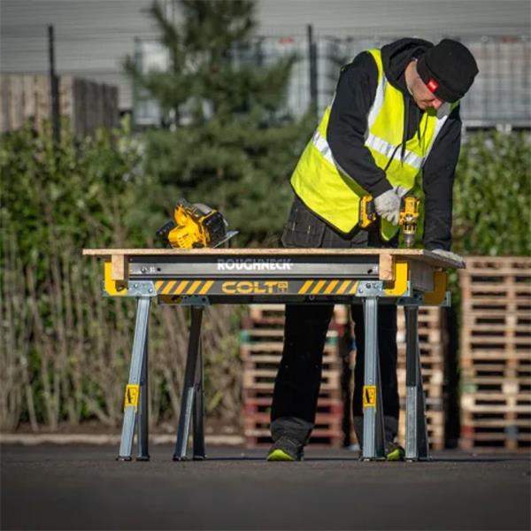 Two Roughneck Saw Horses supporting a wooden board with a person using a drill outdoors