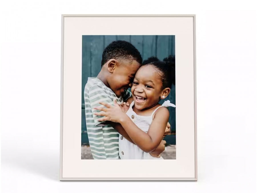 Aura Aspen 12" Wi-Fi digital photo frame in clay grey showing a smiling boy and girl hugging.