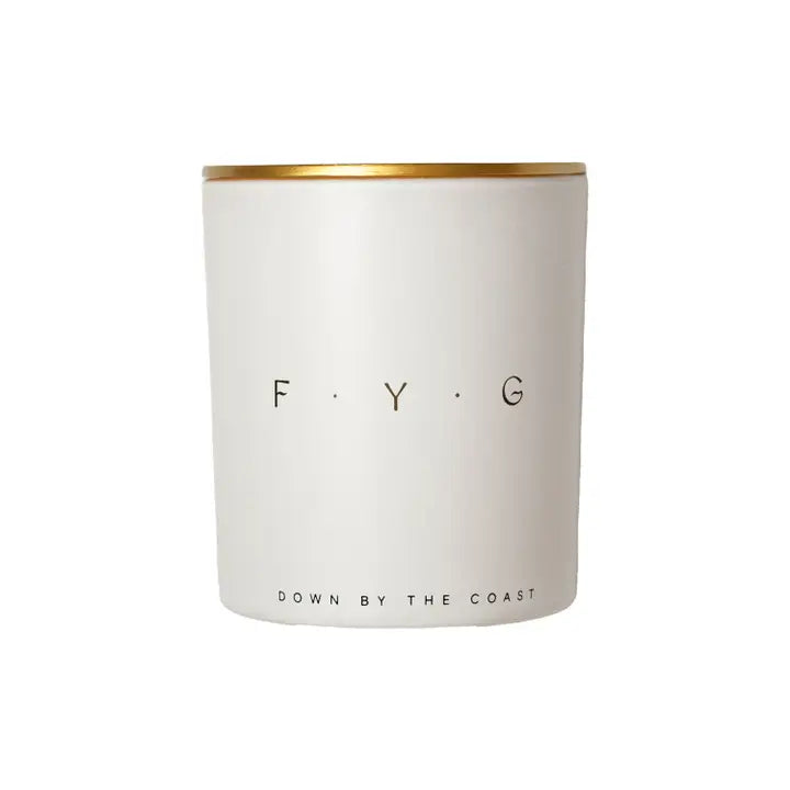 White candle jar with gold rim, labeled "F.Y.G" and "Down By The Coast" on the front.