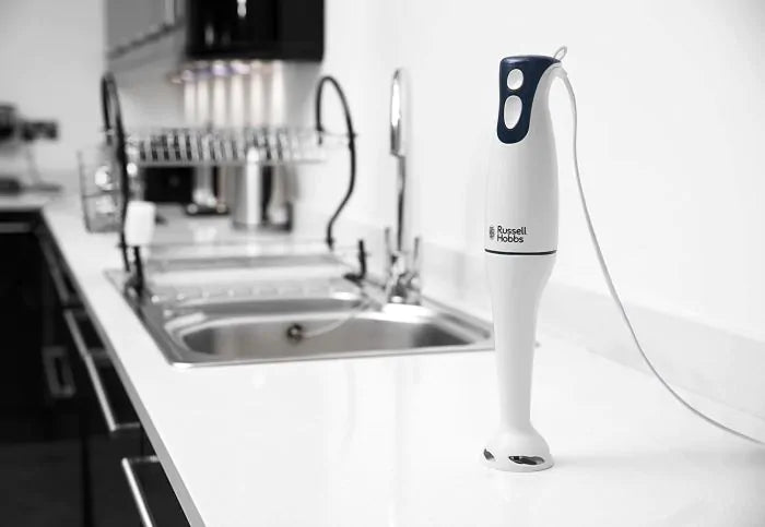 Russel Hobbs Hand Blender 200w standing upright on a white kitchen countertop near a sink.