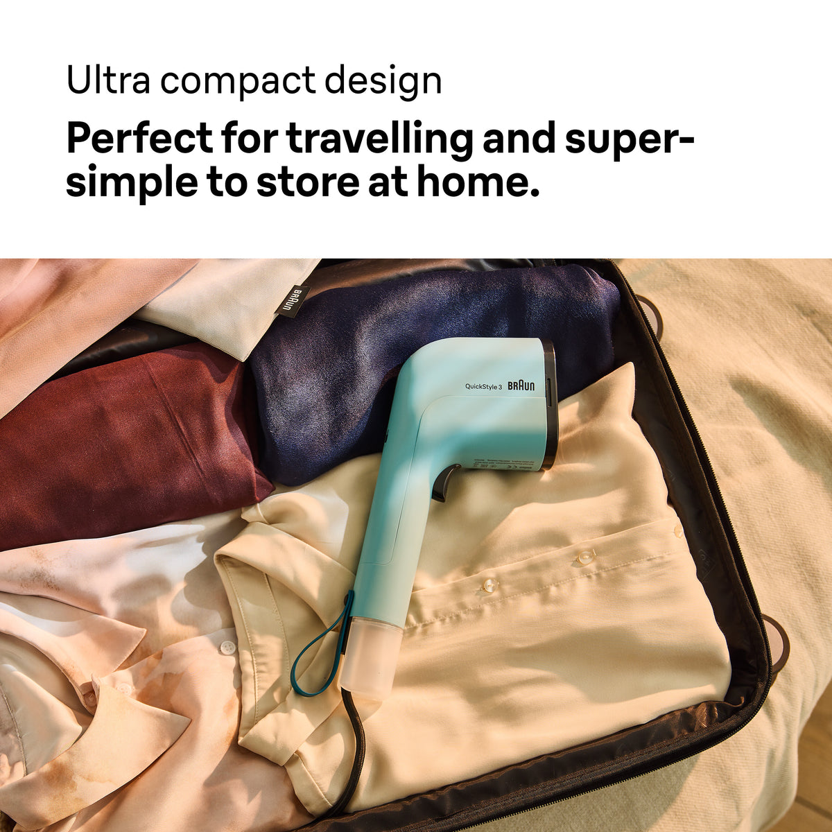 Braun Travel Garment Steamer GS3013GR in light blue packed inside a suitcase with folded clothes.