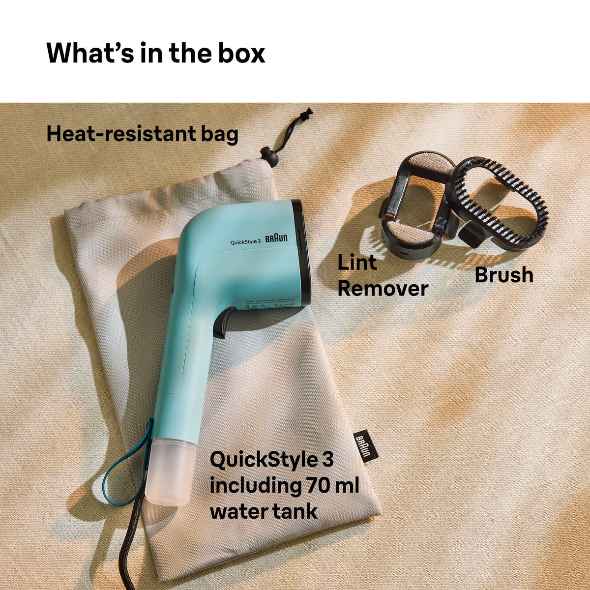 Braun QuickStyle 3 garment steamer with heat-resistant bag, lint remover, and brush attachments on beige fabric.