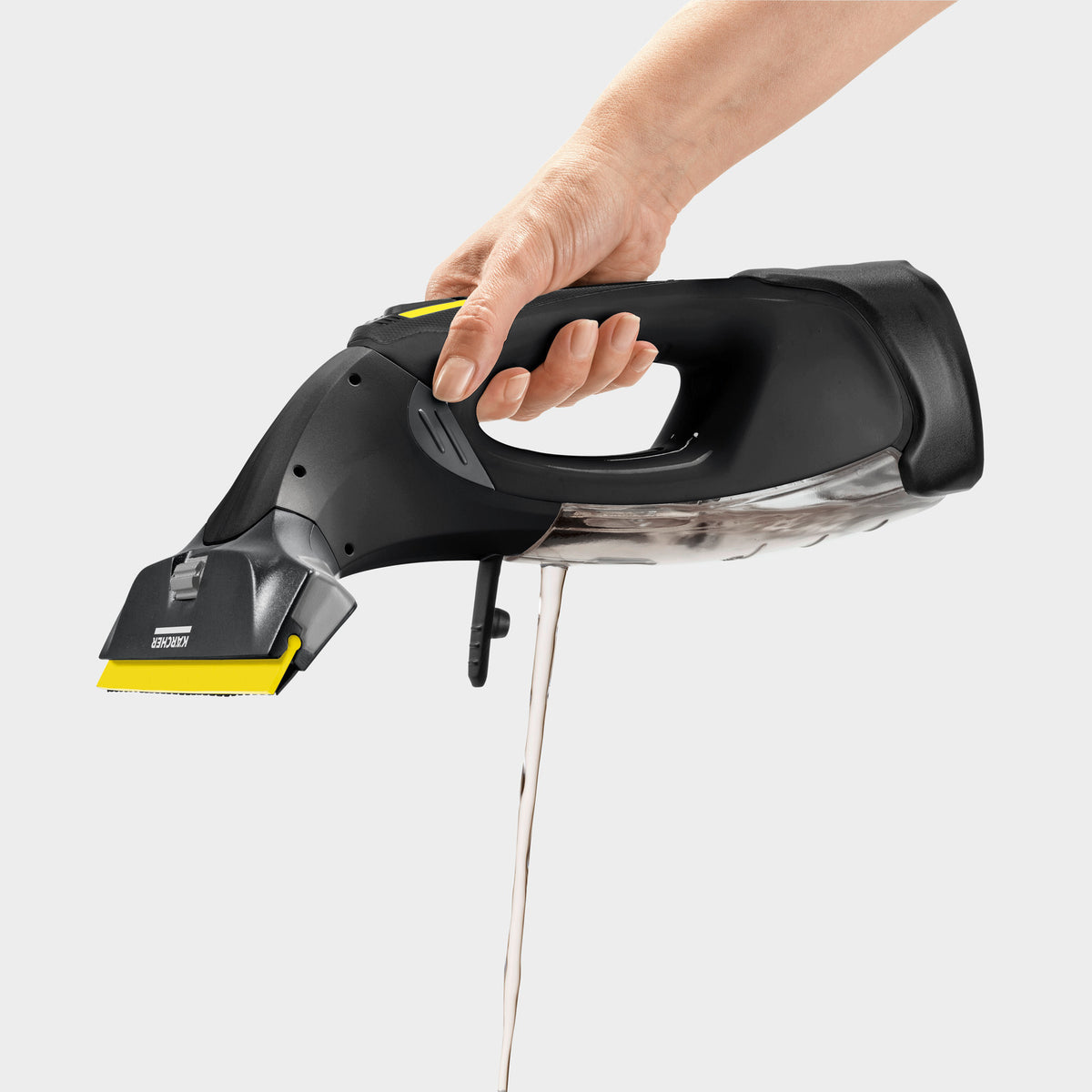 Hand holding Karcher WV5 Anniversary Window Vac with water draining from the transparent container.