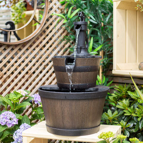 Whiskey Bowls Water Feature with antique pump and cascading water in two wooden barrel bowls on a garden table.