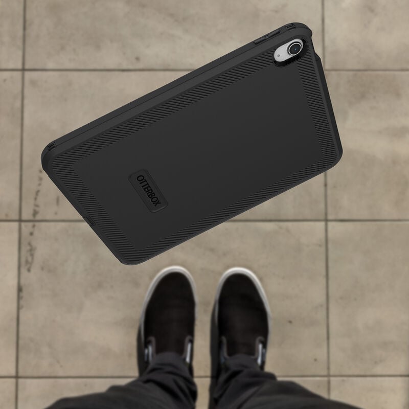 Black OtterBox Defender case for Apple iPad 10th Gen shown from the back with camera cutout and textured edges.