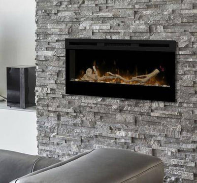 Dimplex 34" Prism electric fireplace with optional driftwood and river rock fuel bed accessory installed on a gray stone