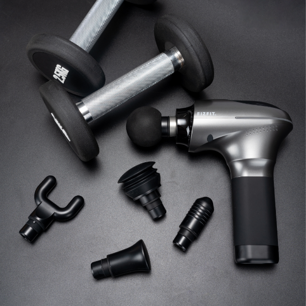 FizFit Massage Gun Elite 2 Space with five interchangeable heads and two dumbbells on a dark surface