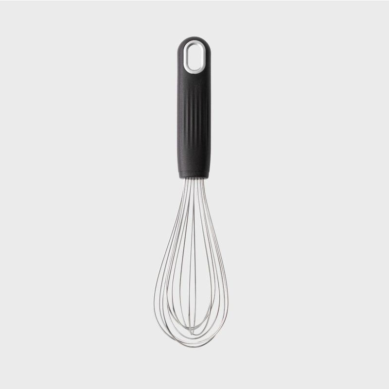 Black-handled kitchen whisk with stainless steel balloon wires on a light background