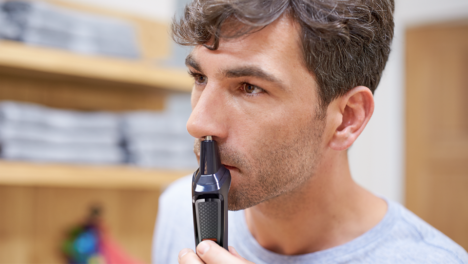 Man using Philips Multigroom Series 3000 nose trimmer attachment for grooming