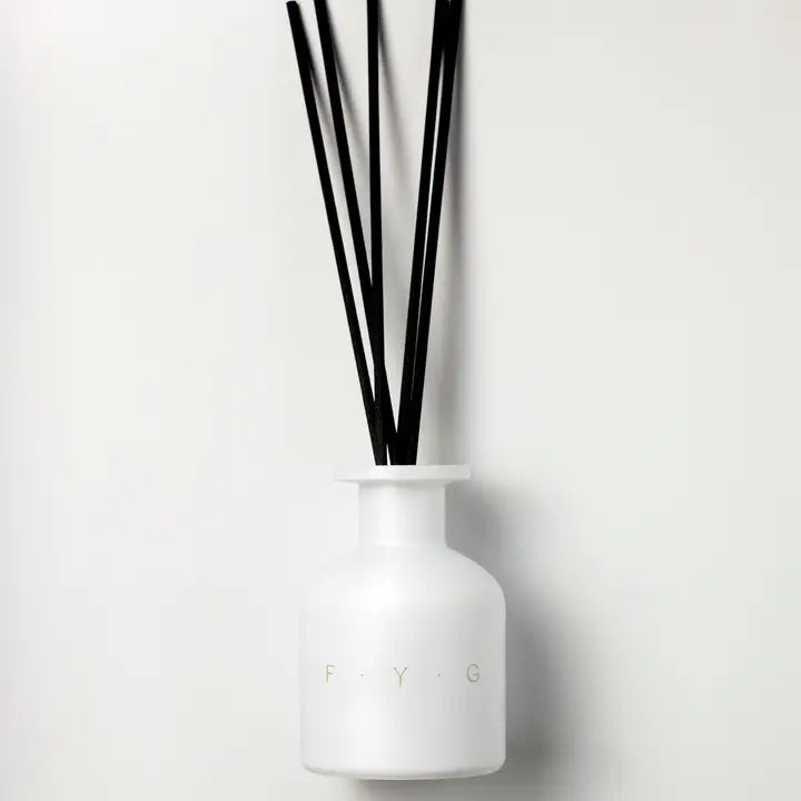 White frosted glass diffuser bottle with black reeds and subtle F.Y.G lettering on front.
