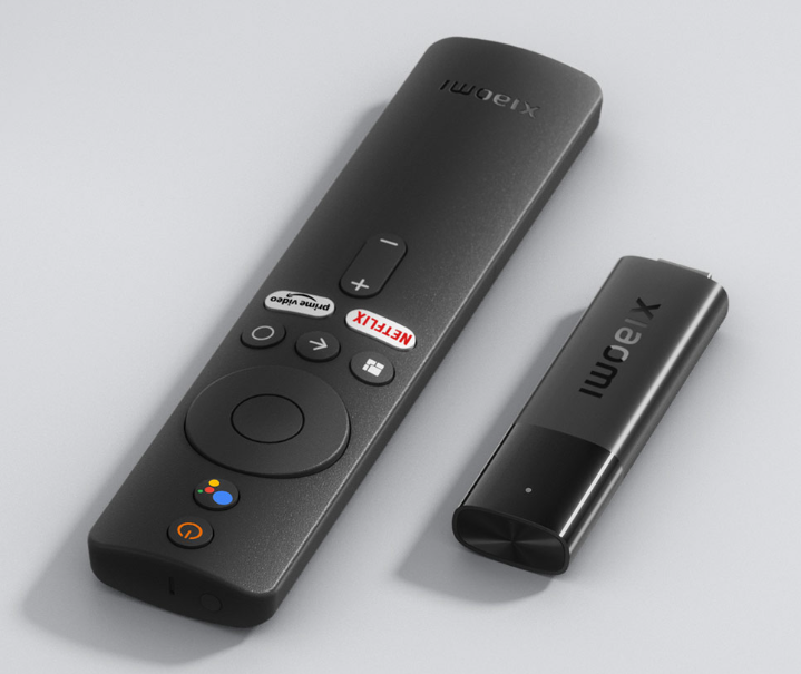 Xiaomi TV Stick 4K with remote control featuring Netflix, Prime Video, and Google Assistant buttons on a light surface