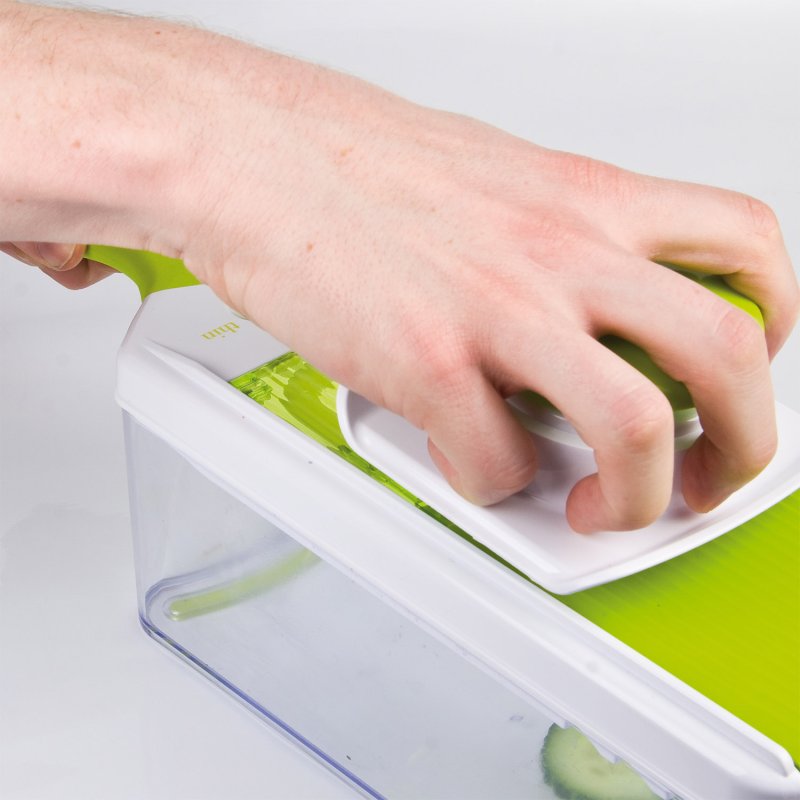 Hand pressing food holder on Clean Eating Multi Mandoline with clear container below on white background