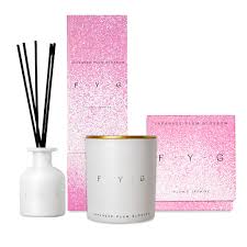 Japanese Plum Blossom Diffuser F.Y.G with white ceramic bottle, black reeds, candle, and pink packaging boxes.